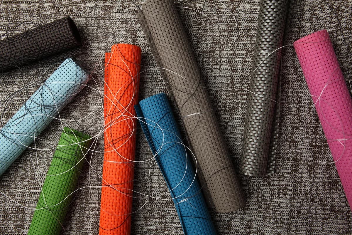 Woven outdoor fabric samples in blue, green, orange, taupe, charcoal and pink