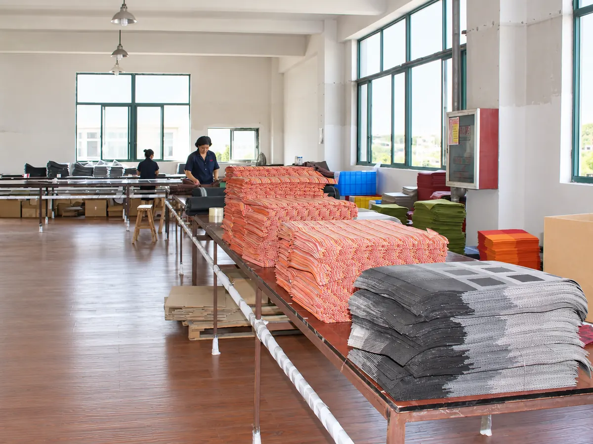 Coral and gray woven fabric samples stacked on textile worktables